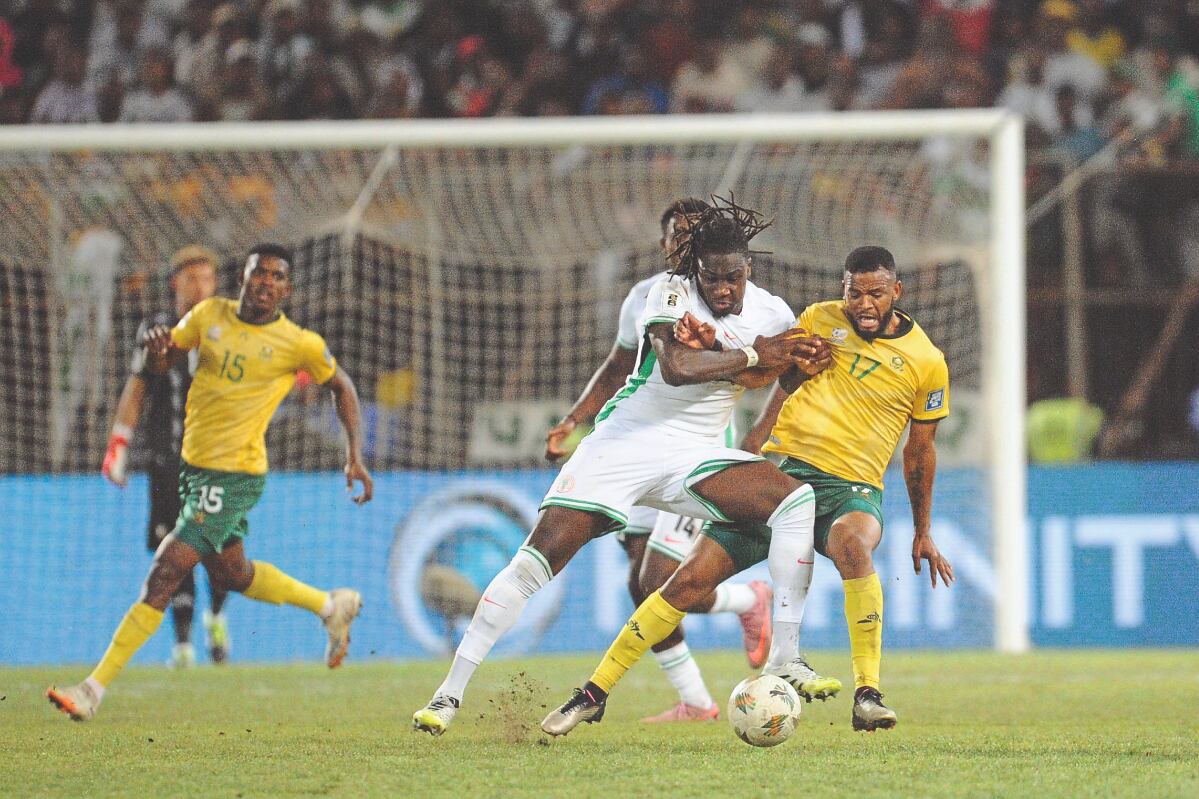 Push and shove: Sipho Mbule (in yellow) battles for possession in Bafana’s 1-1 draw last month against Nigeria during their World Cup qualifier in Bloemfontein
